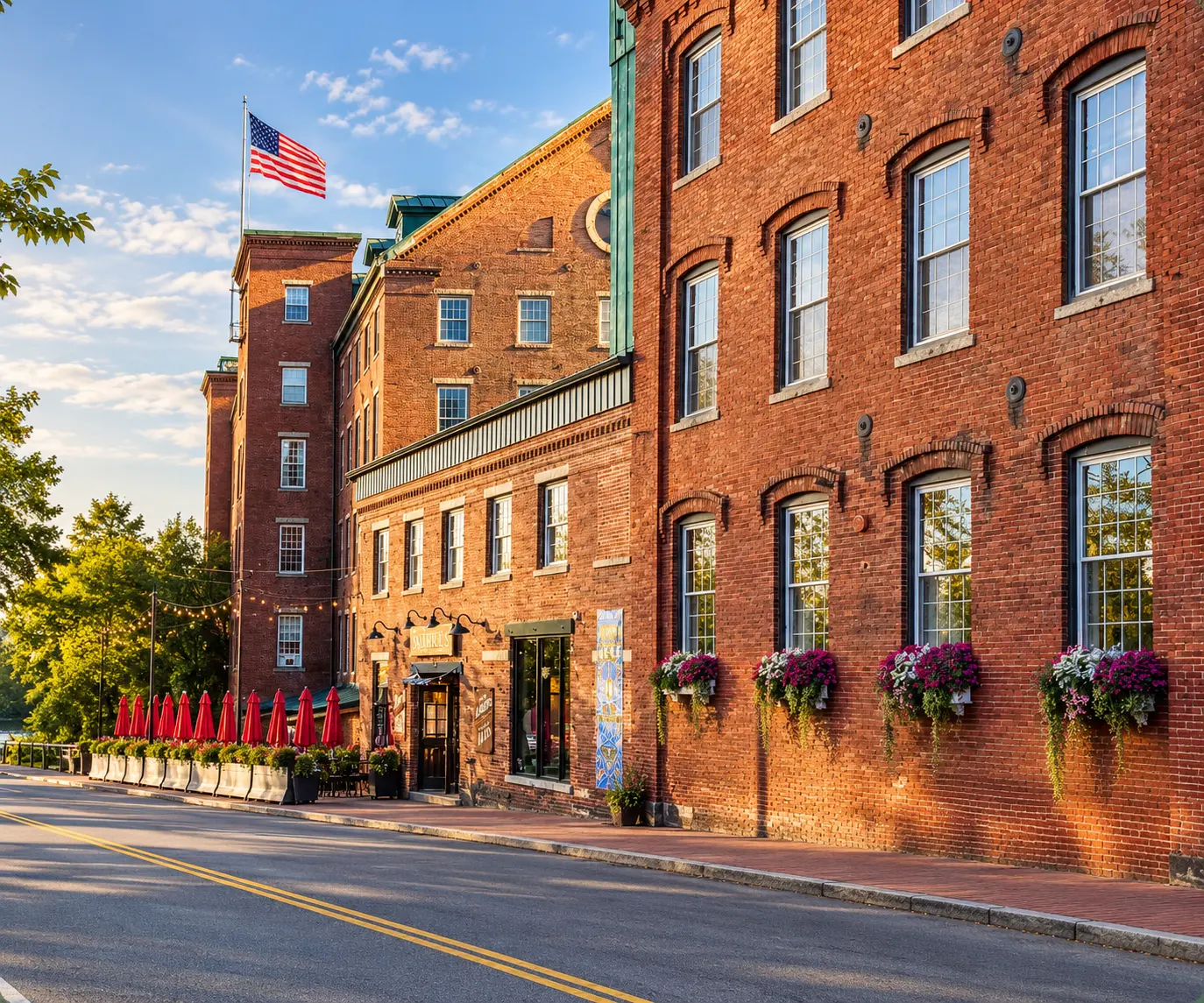 The historic brick mill building in Amesbury, Massachusetts, in warm late-afternoon light